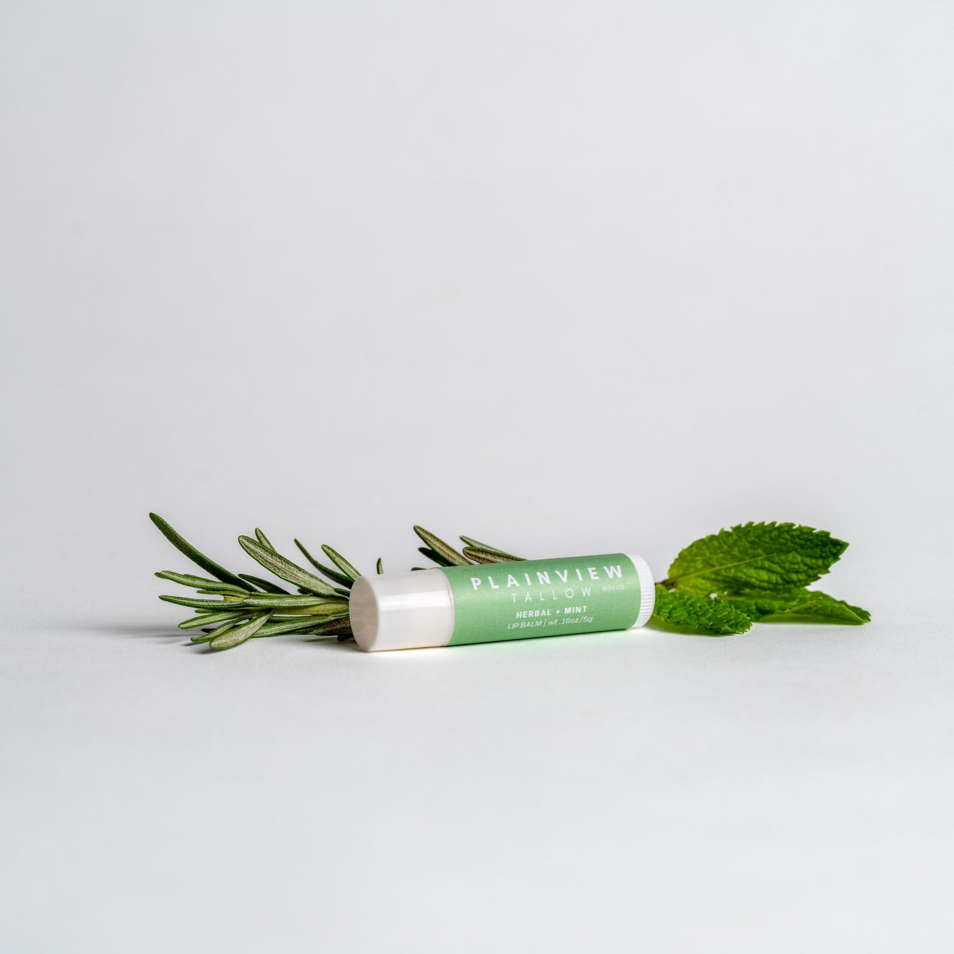herbal and mint lip balm with rosemary and mint leaves
