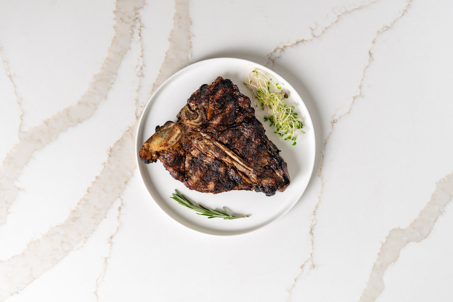 Seared Kansas T-bone steak on plate – premium sprout-finished beef.