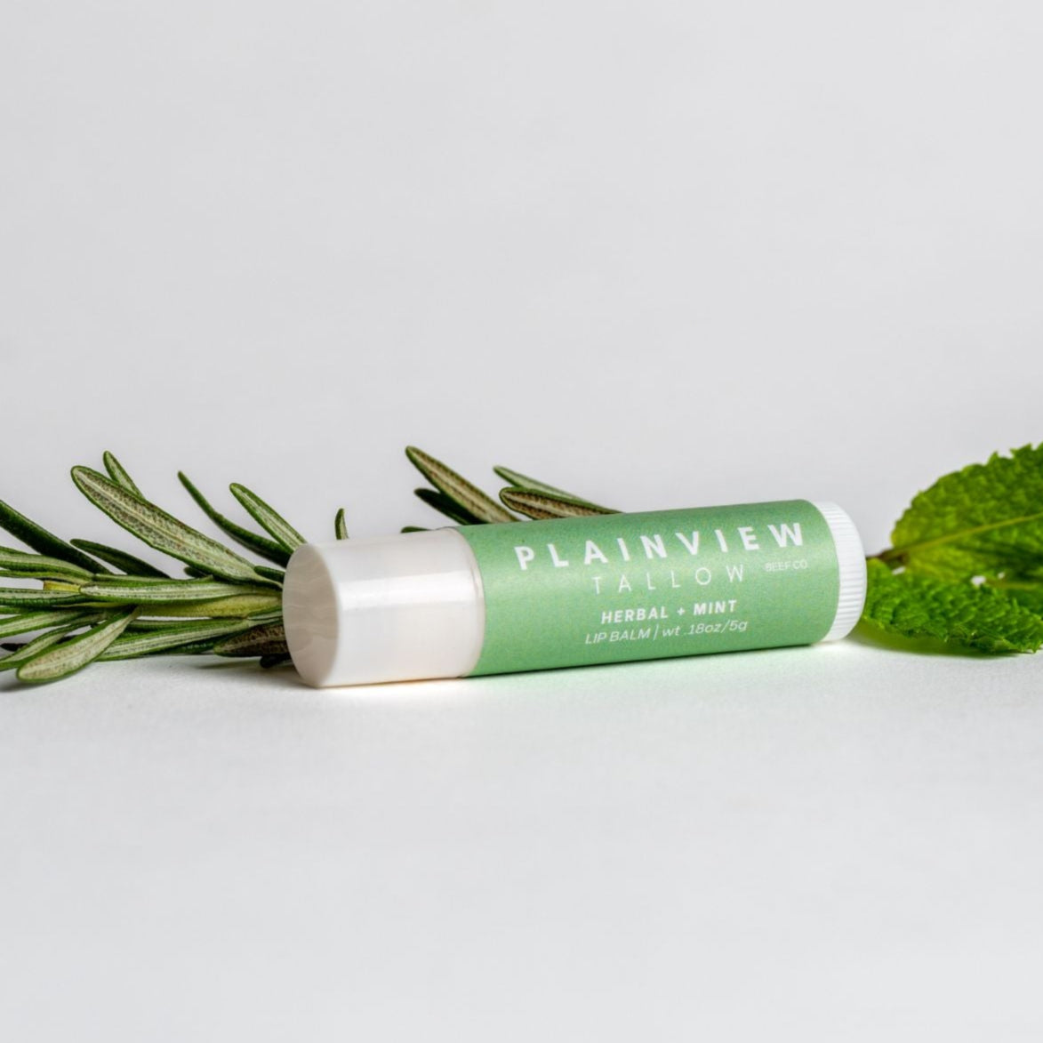 herbal and mint lip balm with rosemary and mint leaves
