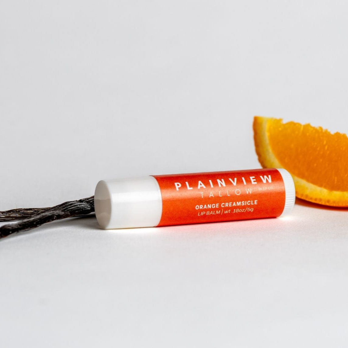 Orange creamsicle lip balm with an orange slice and vanilla bean