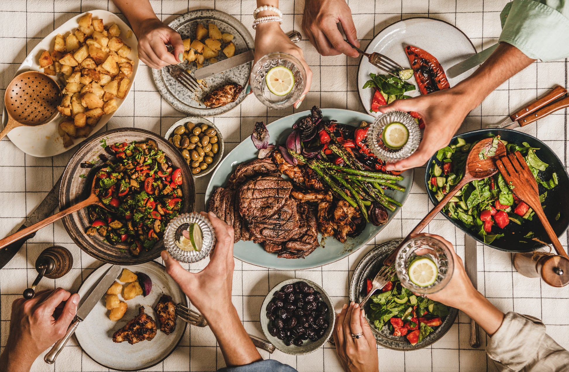 People feasting at barbeque party with meat salad.